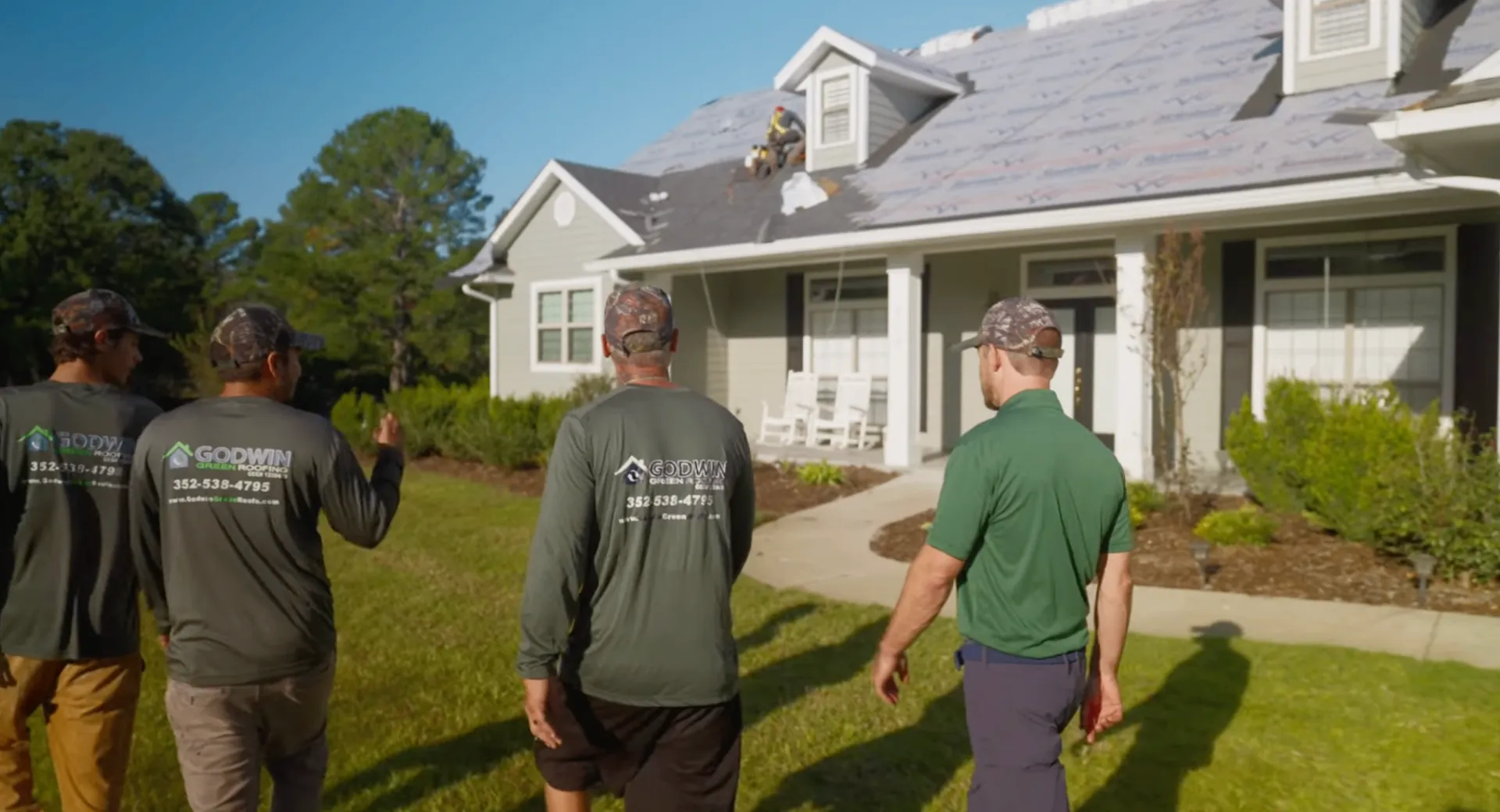 Godwin Green Roofing crew walking toward a Gainesville home
