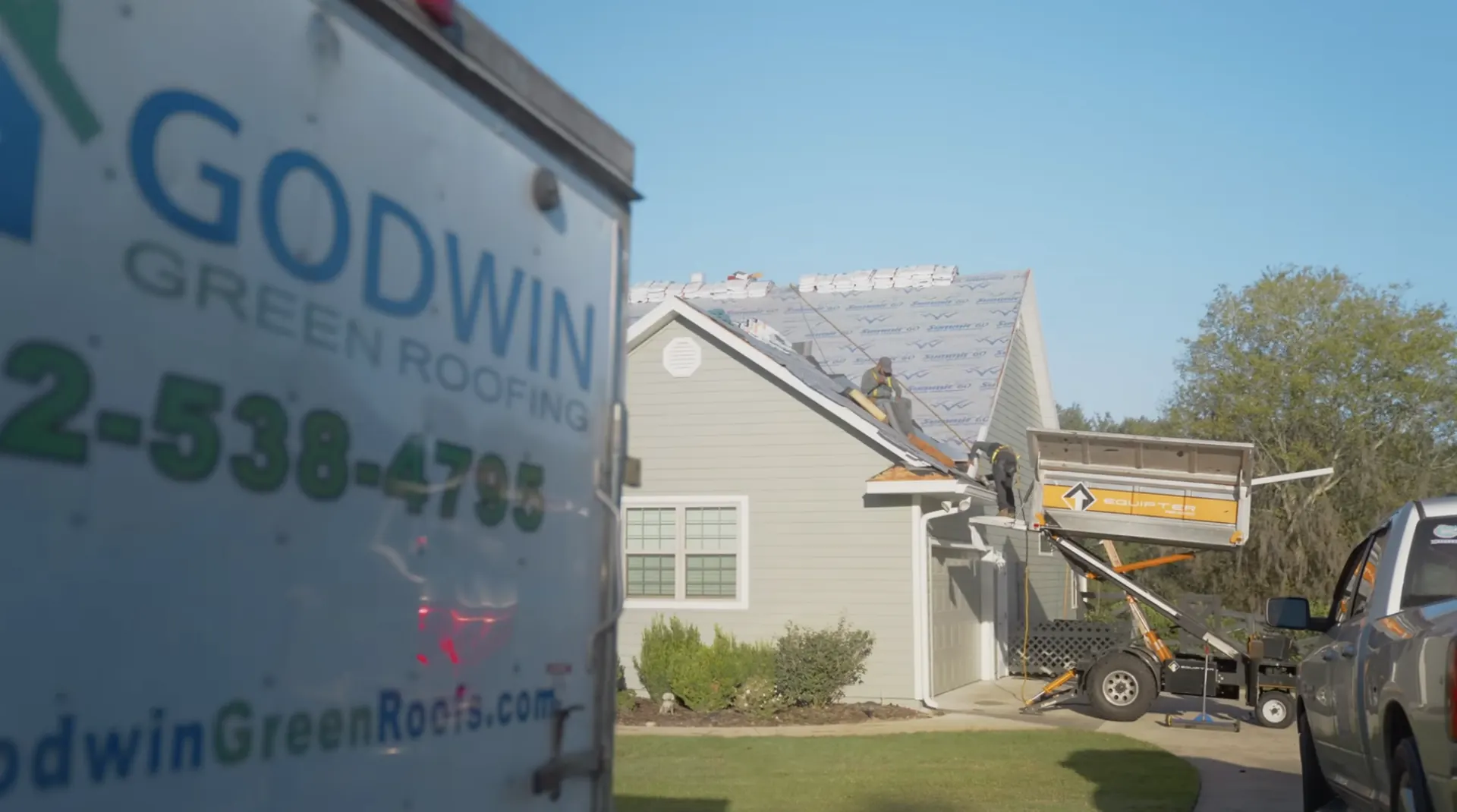 Godwin Green Roofing work truck beside a Gainesville home during roof installation