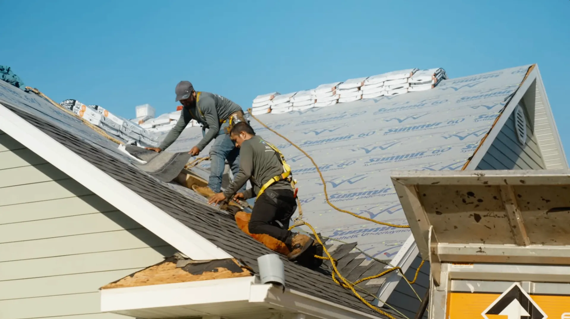 Roofers installing shingles over underlayment on a Gainesville home