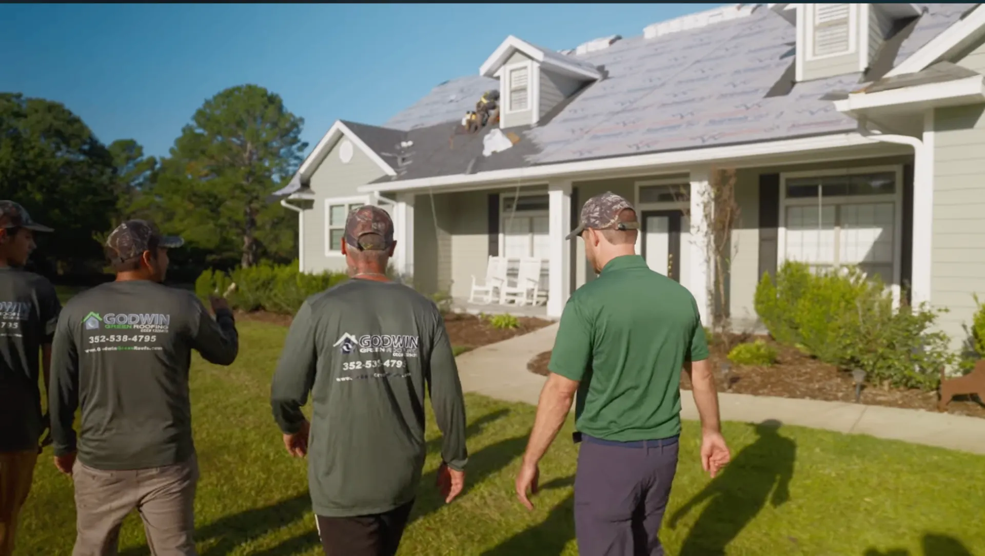 Godwin Green Roofing crew walking toward a Gainesville home during a roof project